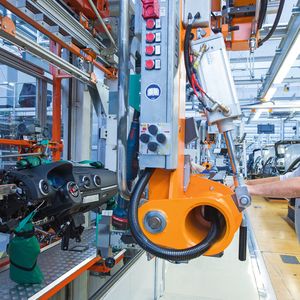 Bild 1: Mit dem Handhabungsgerät kann der Werker das Cockpit praktisch schwerelos transportieren und dann genau im Fahrzeug positionieren.
