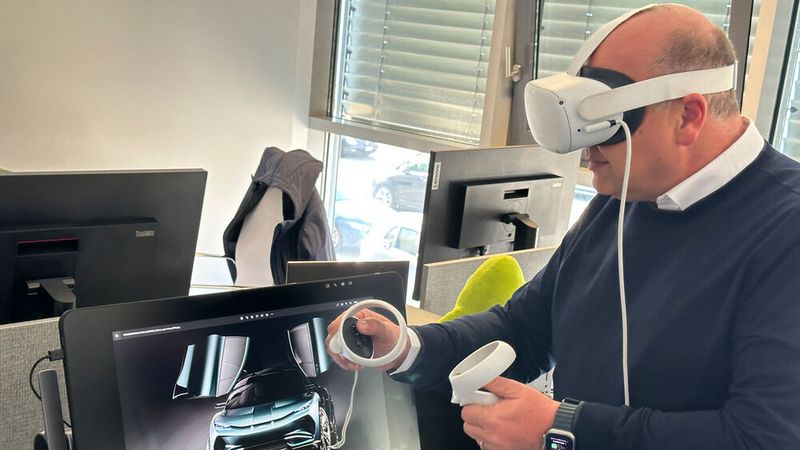 Designchef Filippo Perini zeigt mithilfe einer VR-Brille, wie die Zukunft des jungen Unternehmens aussehen wird. (Bild: sp-x/Benjamin Bessinger)