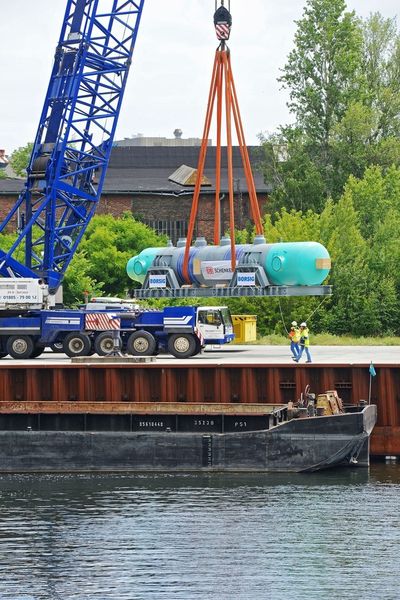 Zunächst wurde der 16 Meter lange Kühler mit einem mobilen 1000-t-Kran im Borsig-Hafen auf ein Binnenschiff verladen. (Bild: Schenker)