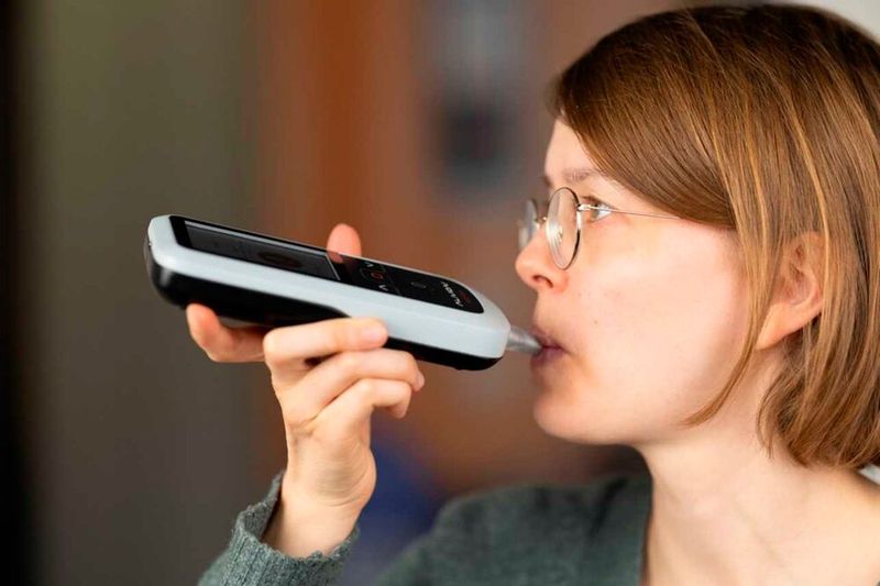 A user performs a breath measurement with the smartphone-assisted breath acetone analyzer. (Source: Alivion)