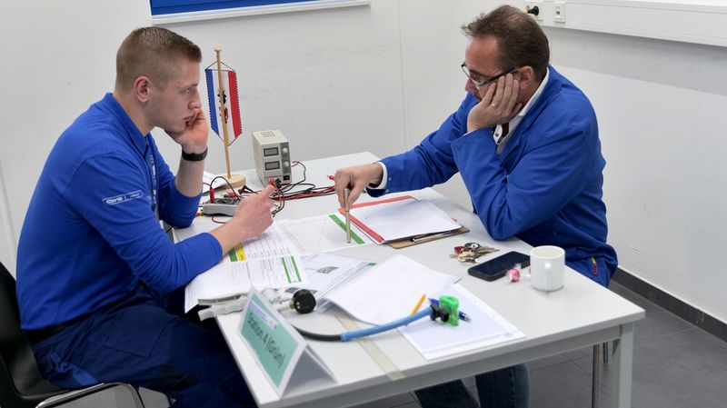 Roderich Weit aus Mecklenburg-Vorpommern erläutert Prüfer Rolf Schneider, wie er die Kennlinie eines Map-Sensors ermittelt hat. Diese Aufgabe war auf Englisch zu bewältigen. (Bild: Schmidt – autoFACHMANN)