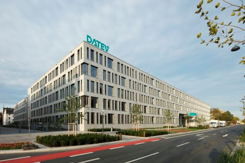 Datev IT-Campus: Hinter der Muschelkalkfassade mit den unregelmäßigen Fenstern arbeiten rund 1.800 Mitarbeiterinnen und Mitarbeiter aus der Software-Entwicklung. Über dem Eingangsbereich schwebt ein „DATEV“-Logo mit aufgestelltem Schriftzug. Die Anlage wurde im Rahmen eines studentischen Wettbewerbs von drei Design-Studentinnen der Hochschule Hof entwickelt. (Bild: Kurt Fuchs/ DATEV eG)