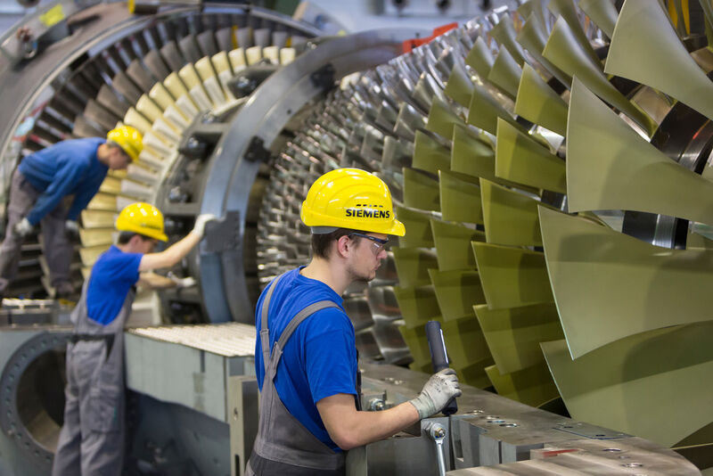 Millimeterarbeit bei der Montage der SGT5-8000H – Mitarbeiter des Gasturbinenwerks Berlin legen den so genannten Läufer in das Turbinengehäuse ein. (Siemens)