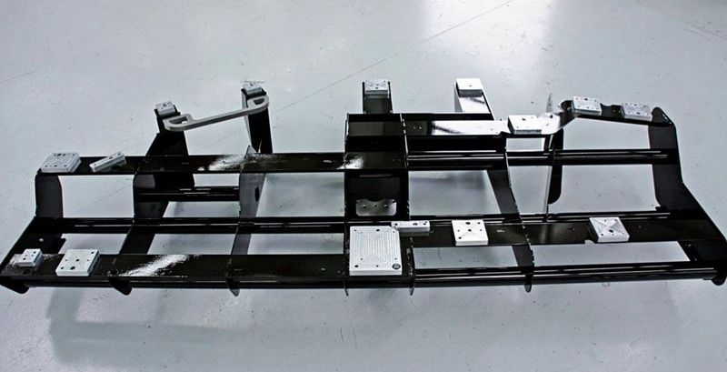 Für die Fertigung von CFK-Fahrzeugkomponenten im BMW-Werk Landshut wurde ein 2300 mm × 1100 mm × 300 mm großer Greiferrahmen entwickelt. Der 26 kg schwere Greifer wurde aus Plattenzuschnitten hergestellt. Er ist für CFK-Preforms konzipiert.  (Bild: IBG)