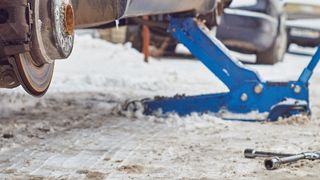 Ein Radwechsel ohne Hebebühne im Freien ist schon im lauen Frühling kein Spaß. Doch das Wetter hält auch noch Schnee, Starkregen, sommerliche Hitzewellen und Sturm bereit. (Bild: © Georgy Dzyura - stock.adobe.com)