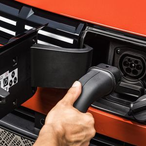 Hinter dem neuen Dacia-Logo in der Front versteckt sich der Anschluss für das Ladekabel.(Bild:  Dacia)