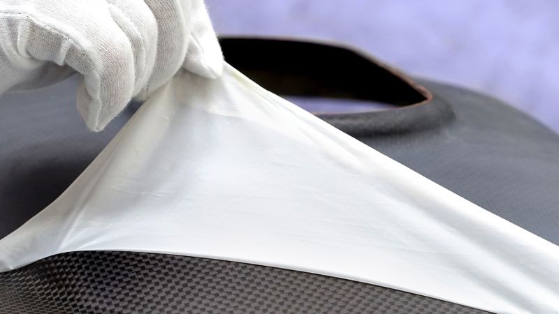 Entfernung der Peelplas-Folie nach Aushärtung eines CFK-Bauteils(Bild:  Fraunhofer IFAM)