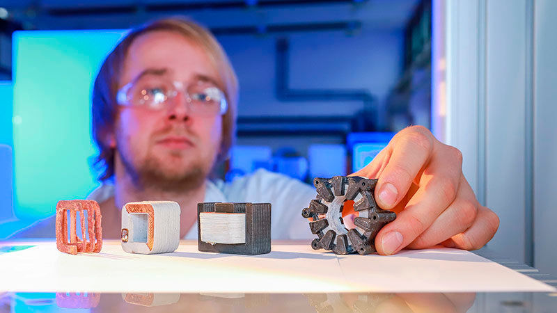 Entwicklungsschritte des 3D-Drucks: Kupferwicklung, keramisch isolierte Spule, Spule mit separat gedrucktem Eisenkern und elektrische Maschine (von links). (Bild: Jacob Müller)