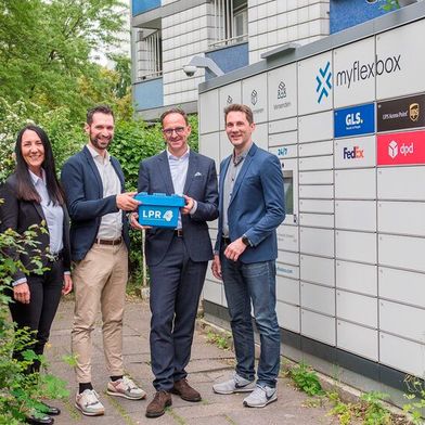 Vor einer Myflexbox in Berlin-Kreuzberg (v.l.): Susan Onorato (Head of Sales LPR Supply), Florian Hanglberger (Head of Logistics & Services Myflexbox), Matthias Hohmann (CEO LPR Supply) und Jonathan Grothaus (CEO & Founder Myflexbox). (Bild: Fotografie Jennifer Sanchez)