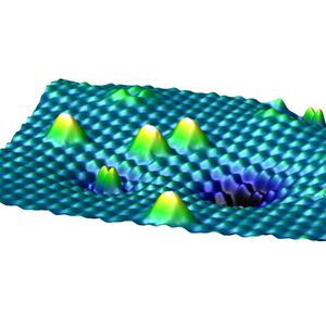 Abb. 2: Eine Rastertunnelmikroskopieaufnahme der Oberfläche von Titandioxid mit verschiedenen Formen von Sauerstoff. Die höheren, weißen Gipfel sind Sauerstoffmoleküle, die auf der Oberfläche sitzen, der kleinere Doppelgipfel im Vordergrund ein bereits eingebettetes Sauerstoffmolekül.