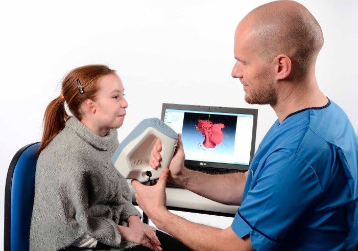 Ein Krankenpfleger benutzt einen -D-Handscanner, um das Ohr von Ellie zu scannen.  (Bild: Artec 3D)