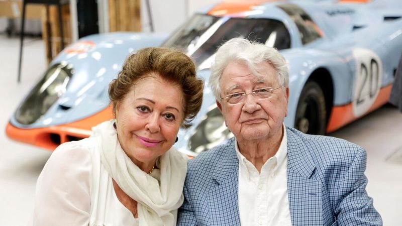 Magdalena Herrmann und Hans Herrmann um 2020. Im Hintergrund ein Porsche 917 K, genauer gesagt der wohl berühmteste Porsche 917K mit der Startnummer 20 aus dem 24 Stunden Rennen von Le Mans 1970. Jo Siffert und Brian Redman gingen mit diesem Auto an den Start, fielen jedoch mit Getriebeschaden aus. Im Jahr darauf spielte das Auto eine Hauptrolle in Steve McQueen's Film 