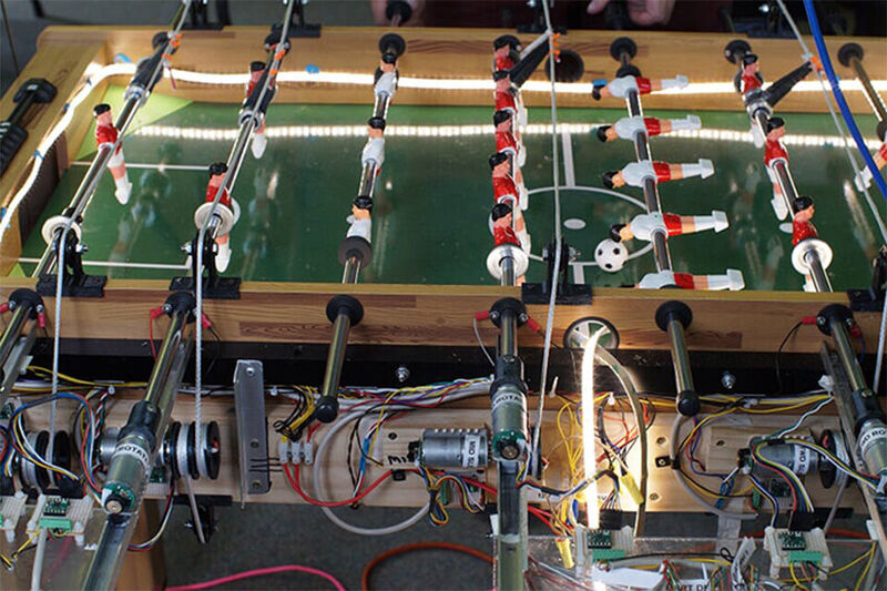 Forscher des Telluride Neuromorphic Cognition Engineering Workshop 2019 arbeiten daran, den Kicker-Tisch der Western Sydney University mit Hilfe von „Loihi“ zu kontrollieren. Sie arbeiten mit visuellem Input von ereignisbasierten Kameras. Kicker bietet einen guten Test für schnelle Closed-Loop-Abtast-, Planungs- und Regelalgorithmen ist quasi einen Sweet Spot für neuromorphe Technologien. (Sumit Bam Shrestha)