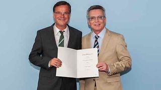 Bundesinnenminister de Maizière überreicht Engelke die Ernennungsurkunde (Bild: BMI)