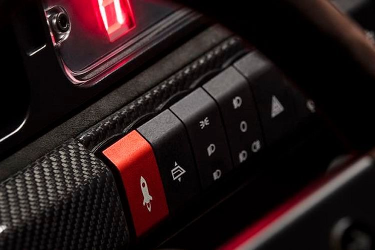 Auch im Inneren wurde der Amos Integrale modernisiert und auf Sport getrimmt, wenngleich z. B. Alcantara bei den Sitze schon noch für etwas Komfort sorgt. Netter Gimmick: Der heute übliche Startknopf ist mit einem Raketensymbol versehen. (Automobili Amos)