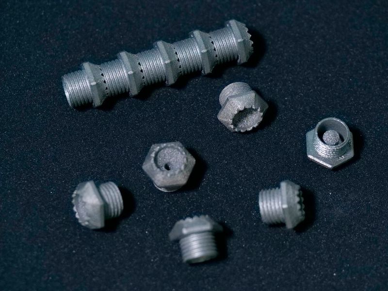 Diese porösen Metallteile wurden auch durch Siemens- und Toolcraft-Know-how additiv gefertigt. Genau gesagt, handelt es sich um schalldämpfende Schrauben mit porösem Einsatz und natürlich Gewinde. (Bild: Siemens)