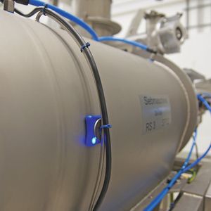 Ein Sensor (blau leuchtend), der an der Fertigungsanlage angebracht wurde, übermittelt die Daten, die von den Start-ups auf dem Hackathon aufgegriffen und in konkrete Projektideen umgesetzt wurden.(Bild:  Oliver Thiel/Zeppelin)