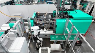 Das ist der neue hybride Arburg-Allrounder des Typs Cube 1800, implementiert in eine Fertigungszelle. Er arbeitet mit einem Würfelwerkzeug, womit die Spritzgießmaschine doppelt so viel produzieren kann, wie eine große mit einem Drehwerkzeug, heißt es. (Arburg)