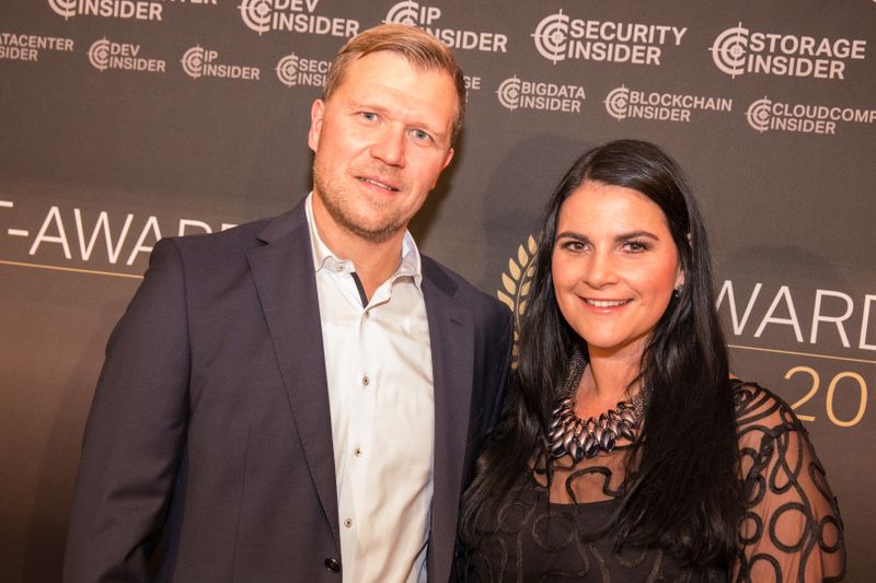 Finden vor der Fotowand zusammen: Barbara Götz (Hitachi Vantara) und Peter Beer (SugarCRM). (artful rooms / Vogel IT-Medien GmbH)
