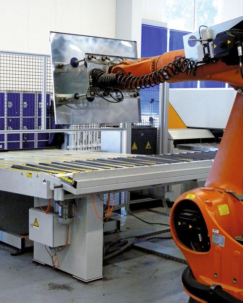 Die in der Biegelinie fertig gekantete Platine wird vom Hauptmanipulator ausgeschleust und von einem Roboter mittels Vakuumsaugern gegriffen. ... (Bild: Kuhn)