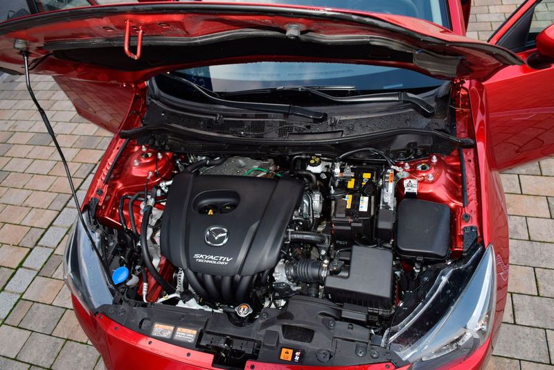 Japantypisch aufgeräumt und servicefreundlich präsentiert sich der Motorraum des Mazda 2. Erfreulicherweise hat ein Teil des Farbzuschlags auch einen Weg unter die Haube gefunden. (Holz / »kfz-betrieb«)
