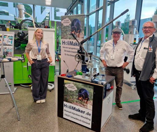 Das Udo-Eckloff-Holimaker-Team auf einer Fachveranstaltung. in der Mitte steht eine manuell bedienbare, äußerst kompakte Spritzgießmaschine namens Holipress des französischen Herstellers Holimaker. Erfahren Sie hier mehr zur Maschine und zu den kommenden Neuheiten.(Bild:  Udo Eckloff)