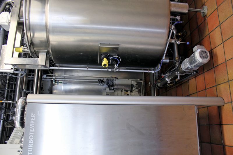 Zwischen Pufferbehälter und Temperiermaschine sitzt die Knoll-Exzenterschneckenpumpe MX30S. Sie sorgt für einen gleichmässigen Förderstrom und somit kontrollierte Kristallisation der Kakaobutter. (Bild: Knoll Maschinenbau)