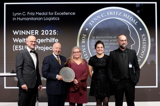 Lynn C. Fritz (2.v.l.) übergibt die Lynn C. Fritz Medal for Excellence in Humanitarian Logistics an die Vertreter der Welthungerhilfe, Florent Chane (r.), Lila Ricart (2.v.r.) und Bärbel Mosebach (Mitte). Links Thilo Jörgl, Juryvorsitzender der Lynn C. Fritz Medal.(Bild:  Sebastian Gabsch / Logistics Hall of Fame)