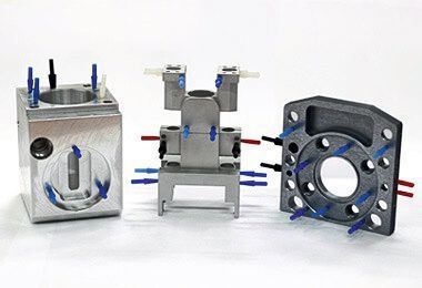 Auszug aus komplexen Aluminiumwerkstücken mit Bohrungen und Passungen, die durch spezielle Abdeckungen vor Oberflächenbeschichtungen geschützt sind. (Gressel)