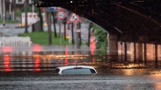Nur das Dach eines Autos schaut noch aus dem Wasser, das eine Bahnunterführung in Nordrhein-Westfalen geflutet hat. (Bild: picture alliance/dpa | Marius Becker)