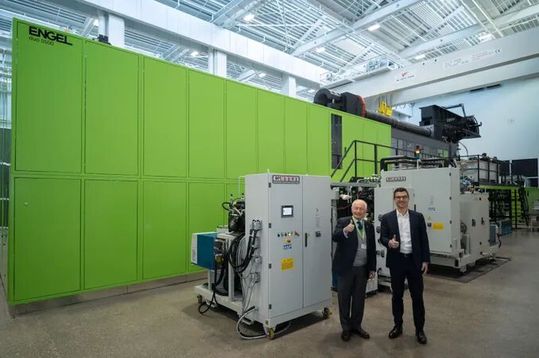 Attraktiv beschichten! Von links: Marco Volpato, Präsident und Vorstandsvorsitzender der Cannon Group, und Stefan Engleder, CEO der Engel Group, vor der weltweit größten Spritzgießzelle mit Polyurethananlage. Hier mehr zur verstärkten Partnerschaft ...(Bild:  Engel)