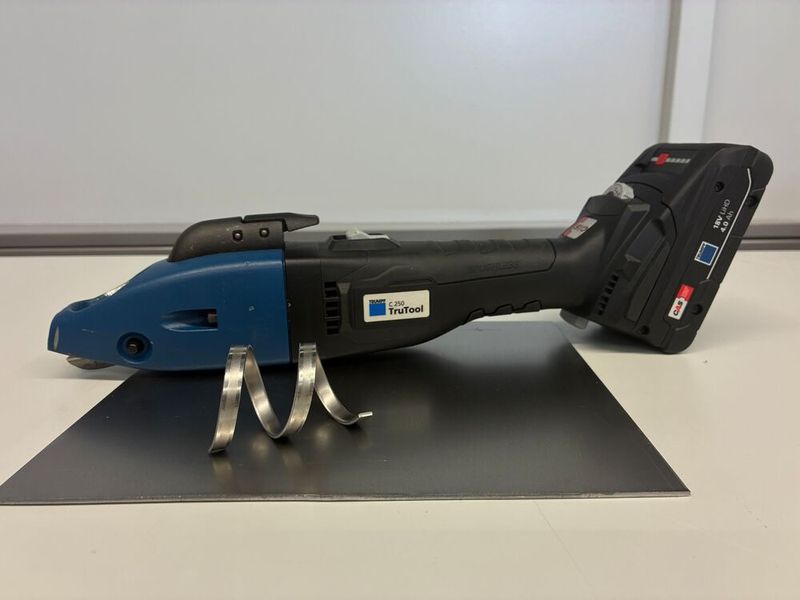 Das ist etwa eine Akku-Schlitzschere von Trumpf. Genauer gesagt, eine aus der Trutool-C-Baureihe. Die Elektrogeräte aus Ditzingen punkten generell mit geringem Gewicht aber hoher Leistung. Hier mit sogenanntem Rollspan dargestellt: Das Blech verwindet sich beim Schneiden deshalb nicht an einer Seite. (Bild: Trumpf)