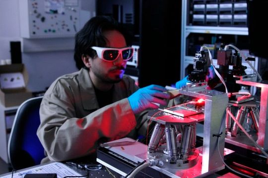 Isabella stellt einen bedeutenden Schritt hin zu einer kompakten optischen Atomuhr dar. Der studentische Mitarbeiter Carlos Gomez misst dafür am Fraunhofer IZM die optischen Eigenschaften eines Glas-basierten photonischen Chips.(Bild:  Fraunhofer IZM)