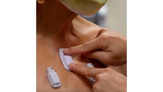 A health care worker sticks wearable devices onto an adult patient's chest.  (Source:Northwestern Medicine)