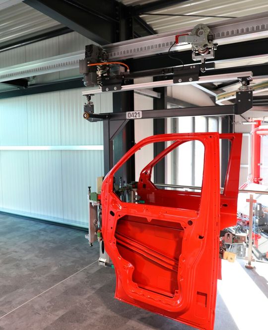 Auch für KMU interessant sein, dürfte das elektrisch angetriebene Leichtbau-Fördersystem Skyrail, das hier eine lackierte Autotür fix und automatisch von A nach B schafft. Namhafte OEMs werden sich demnächst hier die Klinke in die Hand geben, wie SEH betont.(Bild:  SEH Engineering)