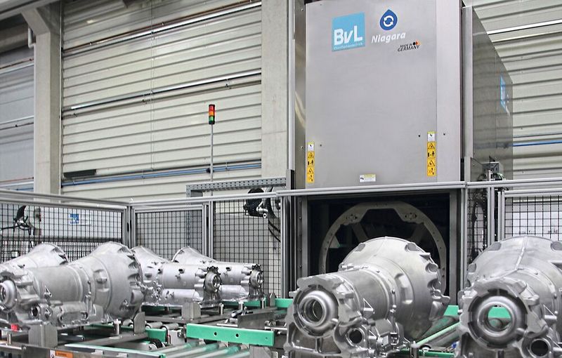 Allseitige Reinigung von Getriebegehäusen bei optimaler Integration der Reinigungsanlage in den Produktionsprozess: Lückenlose Kommunikation zwischen externem Gantry-Kran zur Beladung und einem Roboter zur Entladung.(Bild:  BvL Oberflächentechnik GmbH)