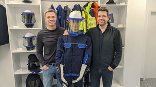 Thomas Jordan (r.) und Lutz Gruschka von BSD zeigen einen für das Arbeiten unter Spannung ausgerüsteten Hochvoltexperten.  (Bild: Rosenow – VCG)