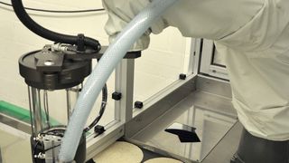 Roboter beim Dressieren von Tortenböden. Wie alle Konditoren in der Backstube trägt auch er einen weißen Schutzanzug. Nur die Haube bleibt ihm erspart. (Bild: Foitzik)