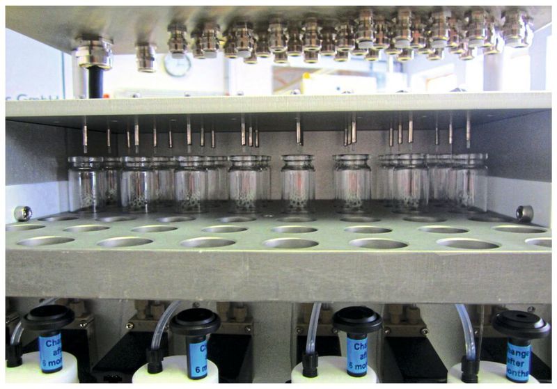 Abb. 1: Detailansicht des Racks mit den Vials und den einzelnen Dosierspitzen. Im Vordergrund sind vier Deckel von Vorlageflaschen mit den Durchführungen der Ansaugschläuche und den Belüftungsventilen zu erkennen. (Simatec)