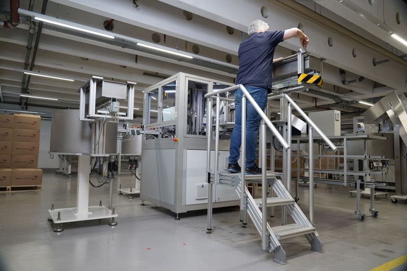 KM Packaging setzt im Montageprozess auch ein Treppen/Podeste-System von Item mit drei Stufen als Aufstiegshilfe ein. Dieses kommt zum Einsatz, wenn Maschinenbediener etwa den seitlich in zwei Meter Höhe angebrachten Behälter mit den benötigten Einzelteilen auffüllen müssen. (Bild: Item / KM Packaging)