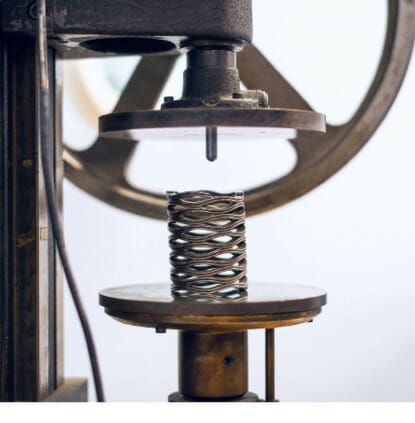 (Bild 1: Die Werkstoffauswahl für die Wellenfedern von TFC umfasst auch Superlegierungen für Einsatzfälle mit erhöhten Ansprüchen an Temperaturfestigkeit, chemische Resistenz und Meerwasserbeständigkeit. Im Bild eine mehrlagige Wellenfeder im mechanischen Prüfstand. Bild: TFC)