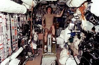 Mir-23-Flugingenieur Aleksandr Lazutkin übt auf dem Ergometer im Basisblock, um sich in der annähernden Schwerelosigkeit der Raumstation fit zu halten. (NASA)