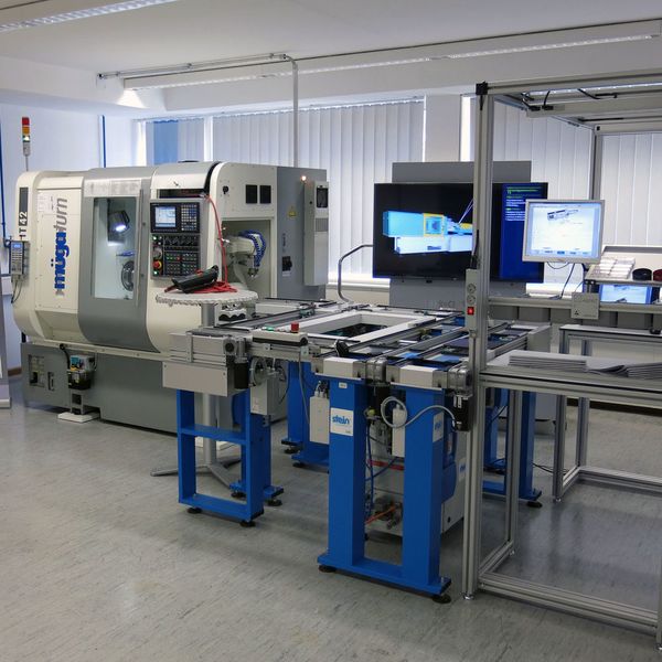 Blick auf die Anlage der Lernfabrik mit Handarbeitsplatz (r.), Transportsystem des Werkzeugträgers und Dreh-/Fräszentrum von müga mit Roboter.  (Feintechnikschule Schwenningen)