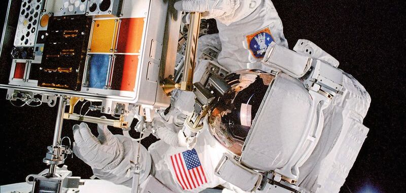 Ein Astronaut montiert eine frühere Version der MISSE-Hardware auf der Internationalen Raumstation während eines Weltraumspaziergangs.