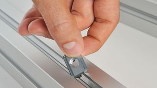 Einschwenklasche für das nachträgliche Einlegen in die Profilnut  (Bild: Maschinenbau Kitz)