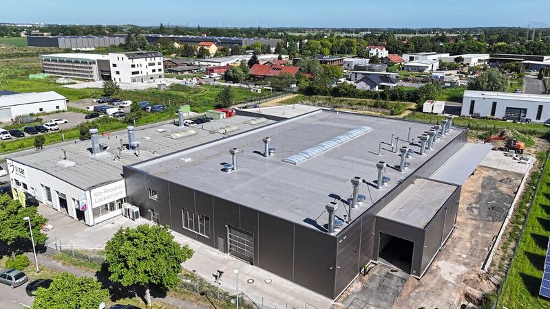 Die neue silbergraue Halle von Isicar in Leipzig übertrifft den bisherigen Betrieb (weiß) in jeder Dimension. Investitionsvolumen: rund sieben Millionen Euro.(Bild:  Isicar)