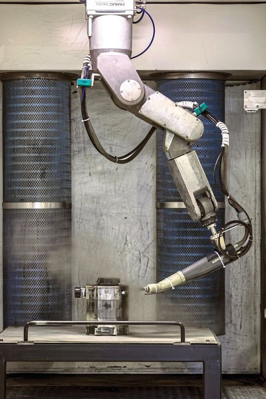 Ein Lackierroboter arbeitet in der Motorreparatur. (Bild:  Fanuc Europe)