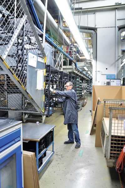 Bild 2: Entnahme der fertig lackierten Teile, die jetzt mit weniger Energieaufwand beschichtet werden können. (Bild: Müller)