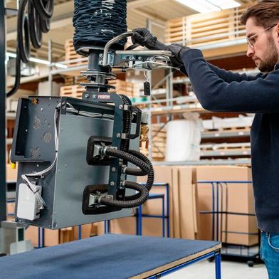 Ergonomische Palettierung: Der „heavyLIFT 80 kg“ mit einem Seitenlifter hebt den Gebläsekonvektor vom Prüftisch und ermöglicht das sichere Umsetzen auf Palette oder Rollenbahn. (Bild: Timmer)