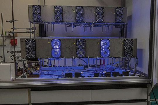 Dieser Photokatalyse-Reaktor wird zur lichtgetriebenen Erzeugung von Wasserstoff genutzt. Die blauen LED-Lichter dienen dabei als Lichtquelle für den photochemischen Prozess.(Bild:  Elvira Eberhardt / Uni Ulm)